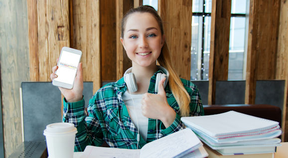 Woman smiling and holding up a phone